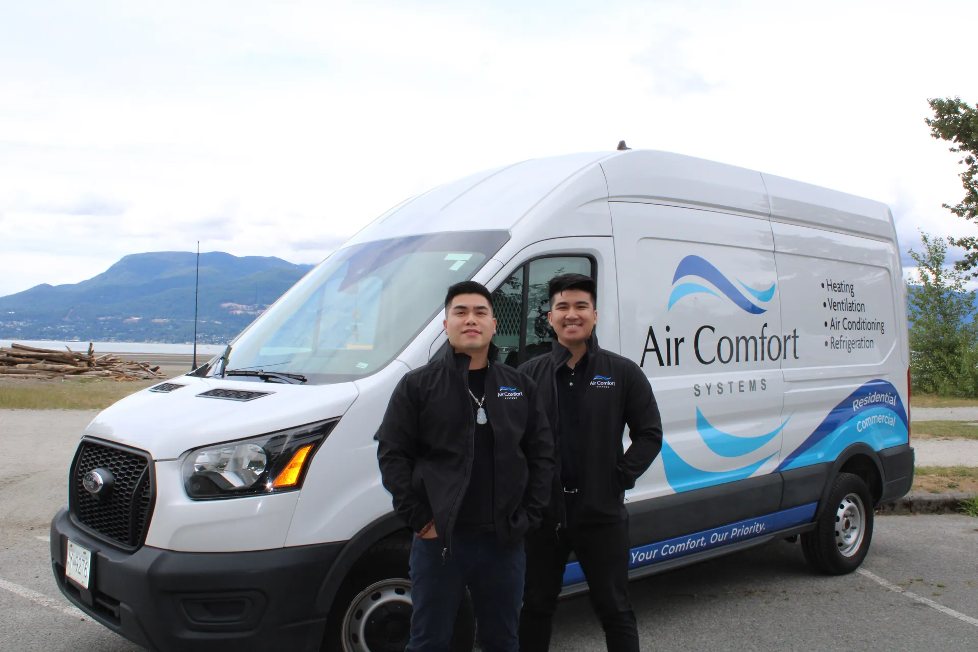 Ed and Larry, owners of Air Comfort Systems, standing in front of their service van